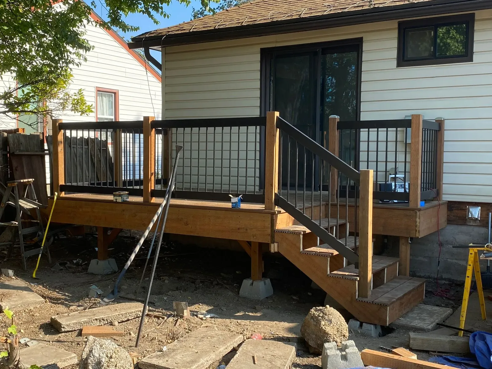 Custom wood deck with black metal balusters and stairs, built by Rew Construction in North Idaho