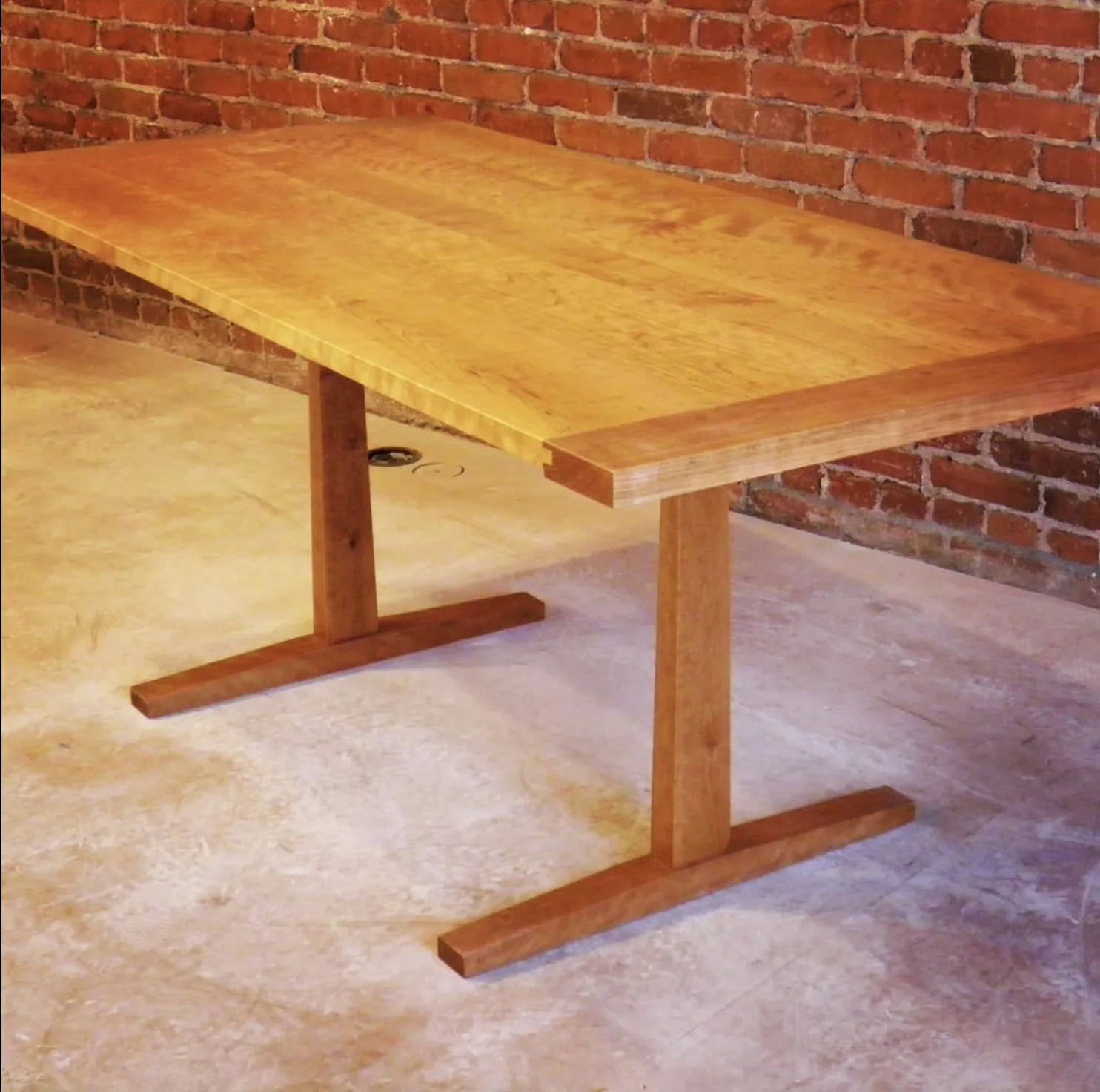 Custom cherry trestle dining table with hand-cut joinery by Rew Construction