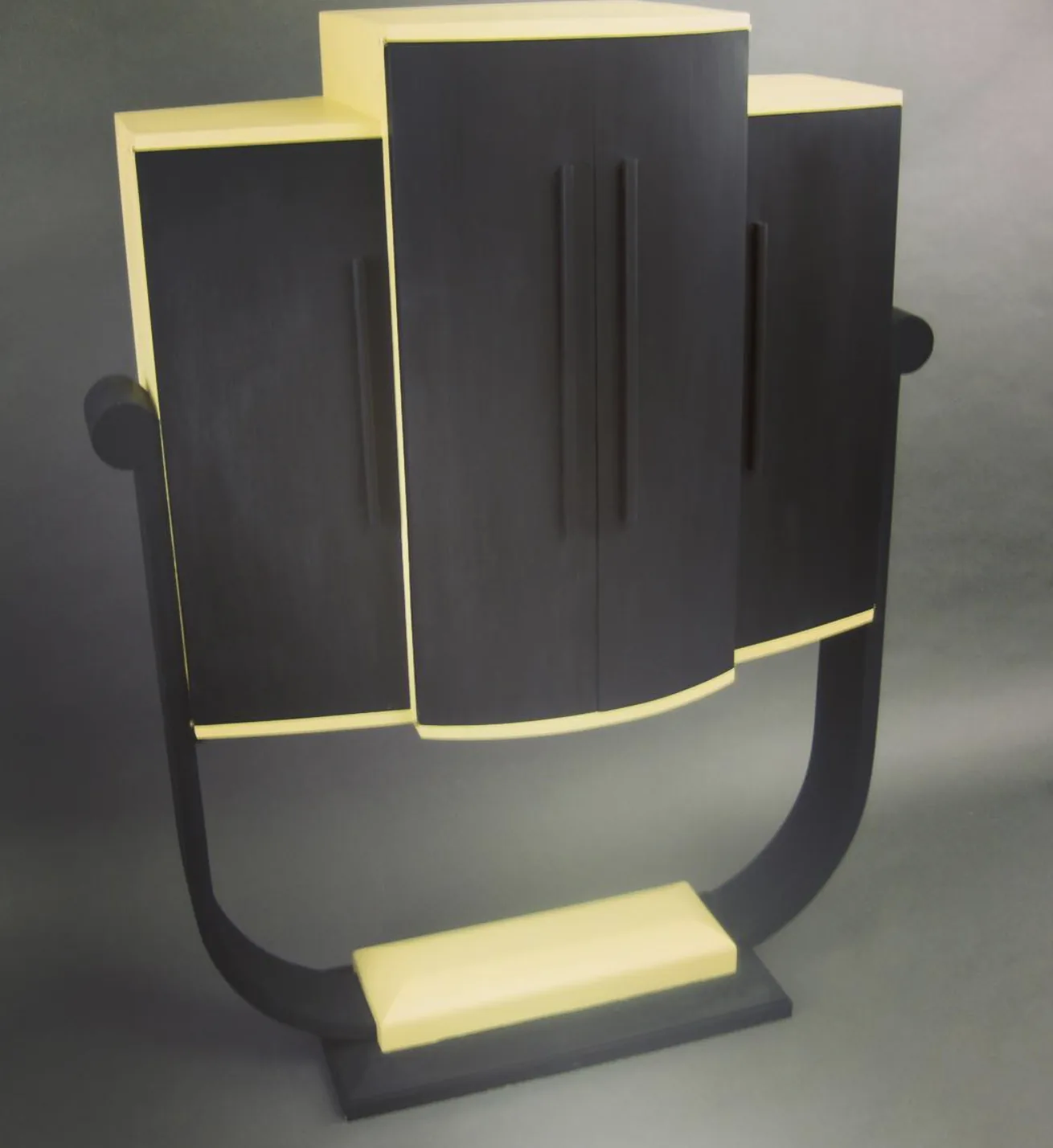 Art deco display cabinet in ebonized and cream finish on a curved stand, custom furniture